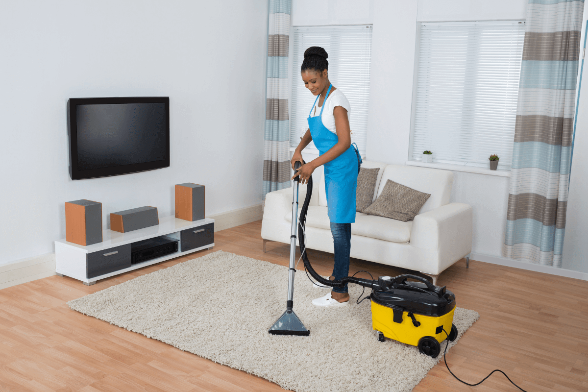 girl happily vacuuming the floor